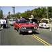 2007 Ford Ranchero - A red convertible is parked on a street with other vehicles and spectators.