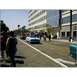 2007 Ford Ranchero - A blue convertible cruises down a street lined with buildings and spectators.