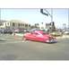 2007 Ford Ranchero - A pink custom coupe is seen from the rear at an intersection with other vehicles present.