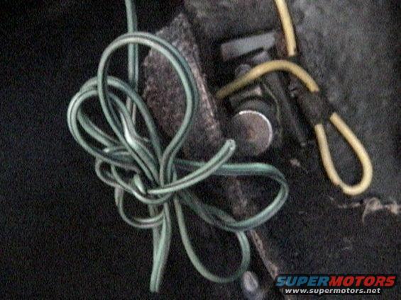 Tangled green and yellow electrical wires, possibly from a vehicle's wiring harness