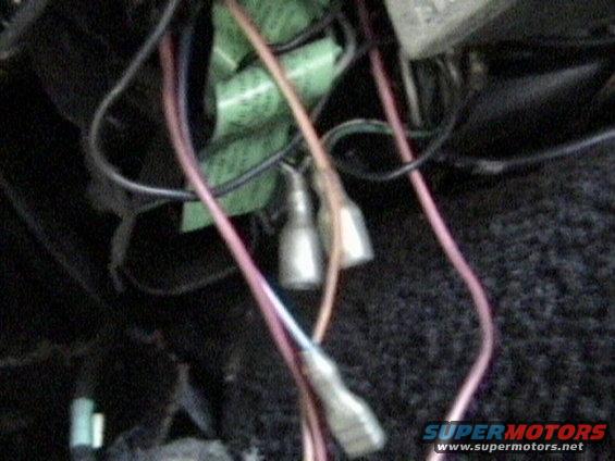 Close-up of a tangled mess of wires and connectors, some with green tape