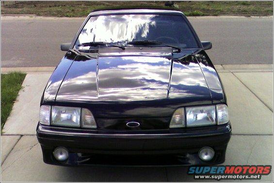 Black Ford Mustang, front view, parked on a driveway