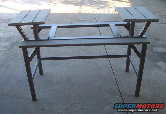 Metal table frame with wooden seats, front view