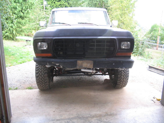 Front bumper and grille of a dark truck with off-road tires