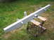 1979 Ford Bronco - A vehicle bumper is shown outdoors, painted gray and mounted on sawhorses.
