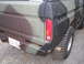 1979 Ford Bronco - Rear view of a camouflage-painted truck, showing the bumper, license plate, and taillight.