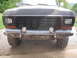 1979 Ford Bronco - Front view of a truck's grille and custom bumper with auxiliary lights.