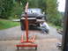 1979 Ford Bronco - Man works on the front end of a 1979 Ford Bronco, with an engine hoist positioned over it.