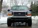2000 Ford F-350 - Front view of a black Ford F-350 truck with a chrome grille and orange turn signals, parked on a wet surface in winter.