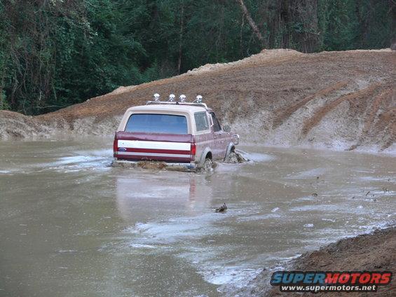 Ford Bronco driving through a muddy water obstacle