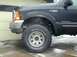 2000 Ford F-350 - Front view of a black 2000 Ford F-350 Super Duty showing the fender, headlight, and tire.