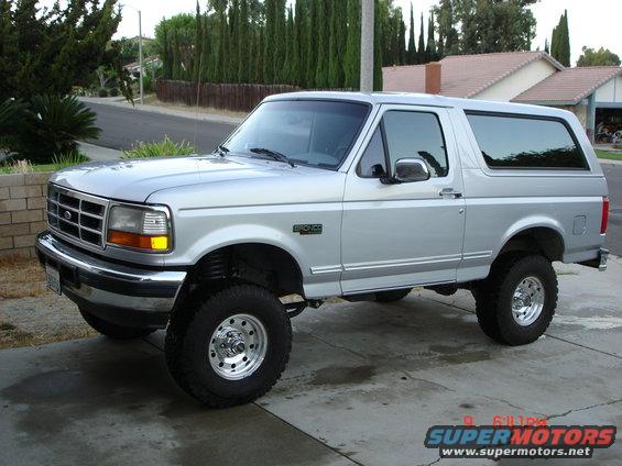 Silver 1996 Ford Bronco parked on a driveway, front 3/4 view, lifted suspension