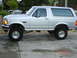 1996 Ford Bronco - This lifted 1996 Ford Bronco is shown in profile, aftermarket chrome wheels and a silver exterior.
