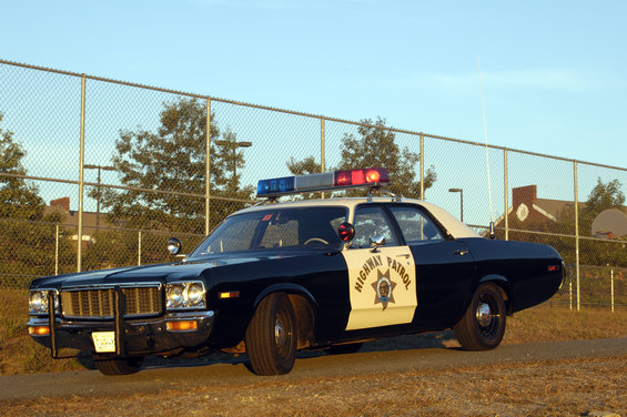 1973 Dodge 1500 police car with 'HIGHWAY PATROL' on door, parked outdoors