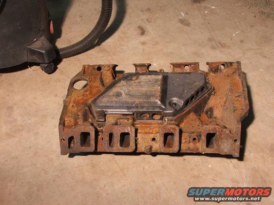 Rusted intake manifold with black cover and exhaust ports