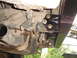 1989 Ford Bronco - Close-up view of the vehicle's undercarriage, focusing on the exhaust system and a newly installed bumper bracket.