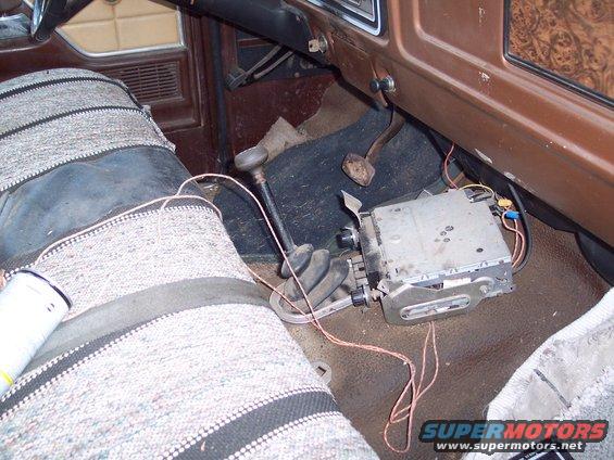 Car interior showing a floor shifter, aftermarket radio, and patterned seats