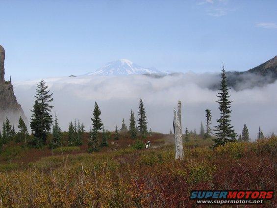 Motorcycle on a trail with a mountain and clouds in background