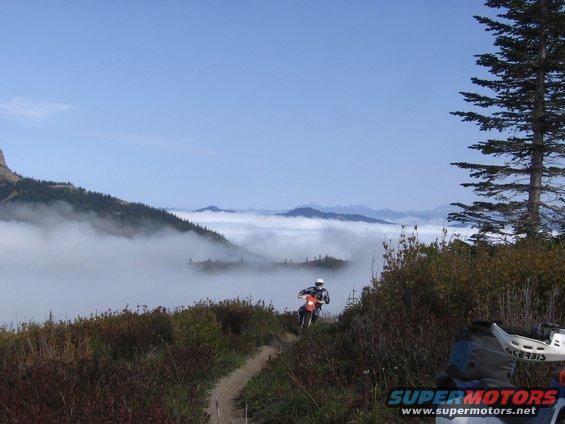 Dirt bike on a mountain trail with fog in the valley below