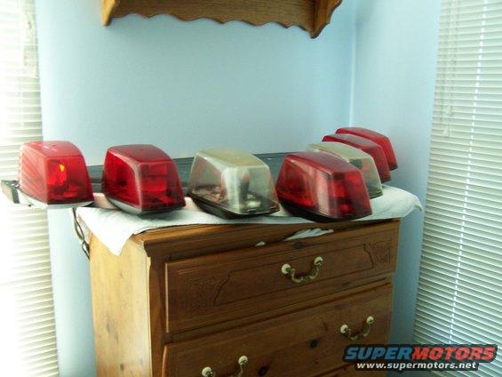 Several red and clear emergency lights arranged on a dresser