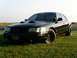 2001 Ford Crown Victoria - This black 2001 Ford Crown Victoria features aftermarket hood scoops and black wheels, seen here parked on a grassy field.