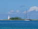 1997 Toyota Land Cruiser - A sailboat glides across the water near a lighthouse on a sunny day.