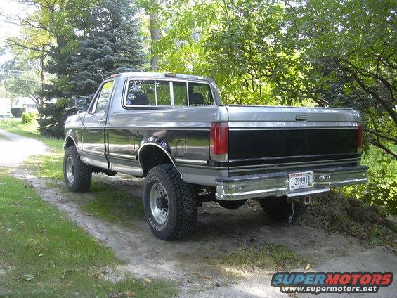 Rear view of a gray and black 1987 Ford F-150 pickup truck with lifted suspension