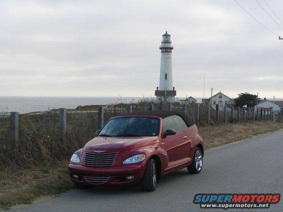 Red 2005 Chrysler PT Cruiser convertible parked near a lighthouse