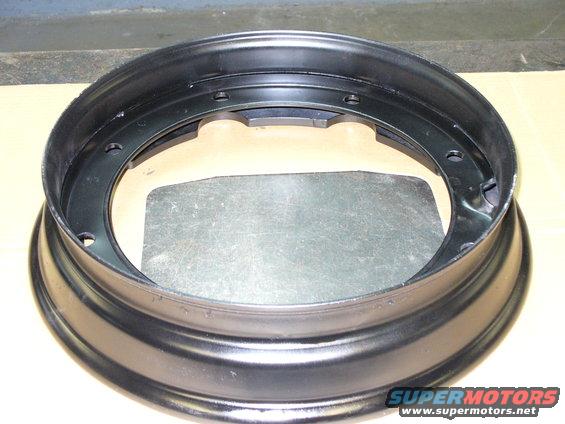 Black steel wheel rim with bolt holes and a metal plate inside