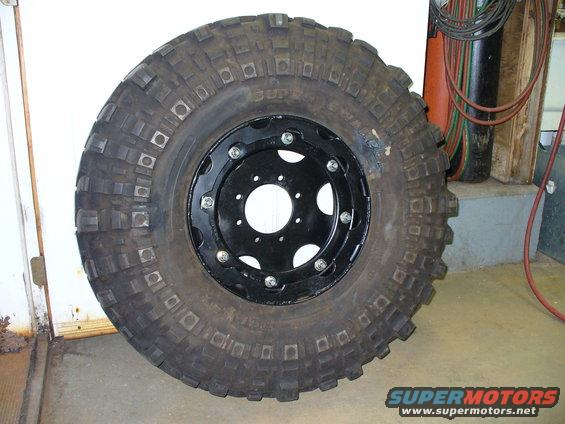 Off-road tire mounted on a black multi-lug rim