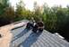 1996 Ford Bronco - Workers take a break on a partially shingled roof, with trees in the background.