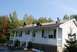 1996 Ford Bronco - Workers are on the roof of a house, performing repairs under a clear blue sky.