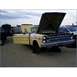 1973 Ford Ranchero - Junkyard scene with a yellow 1965 Ford F-series pickup truck, hood up, and other vehicles in the background.