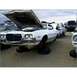 1973 Ford Ranchero - A white 1972 Ford Gran Torino sits in a junkyard with its hood open and resting on tires.