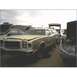 1973 Ford Ranchero - A tan and brown station wagon sits in a junkyard under a cloudy sky.