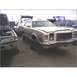 1973 Ford Ranchero - A beige station wagon with wood paneling sits in a junkyard, its front end facing the camera.