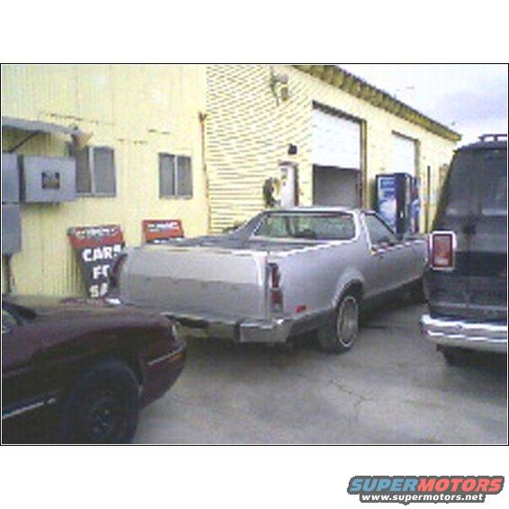 silver pickup truck parked outside building with two other vehicles