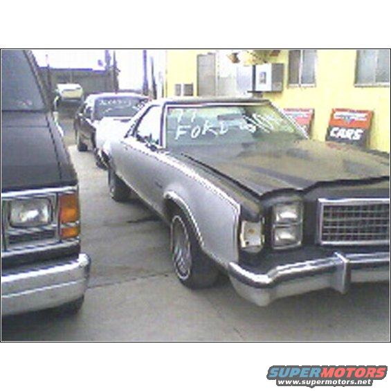 Silver and black pickup truck with '77 FORD written on windshield