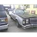 1973 Ford Ranchero - A silver and black pickup truck is parked next to another vehicle, with '77 FORD written on its windshield.