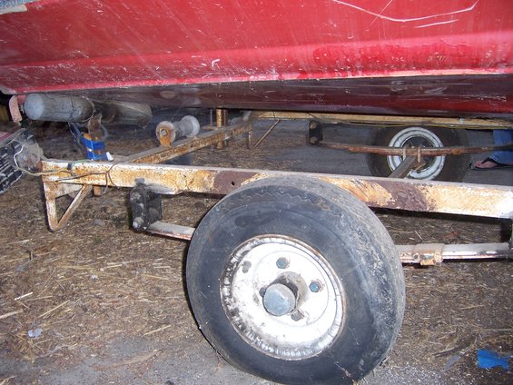 Red boat on trailer, close-up of trailer wheel and frame