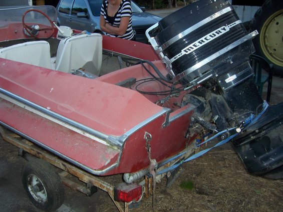 Red boat with Mercury outboard motor on trailer