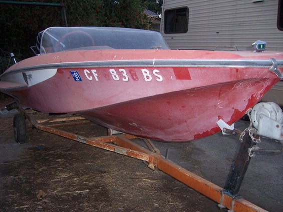Red boat on a trailer with registration CF 83 BS
