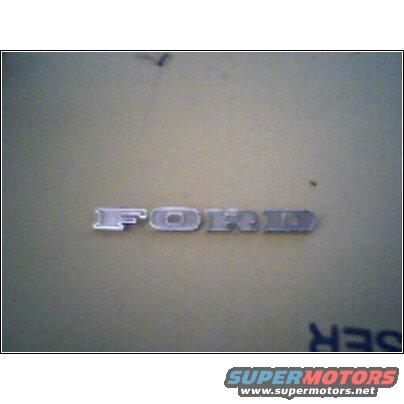 Close-up of a chrome Ford emblem on a tan surface
