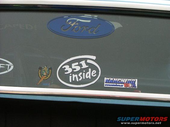Ford oval badge and '351 inside' sticker on a vehicle's rear window, with a Ranchero sticker visible