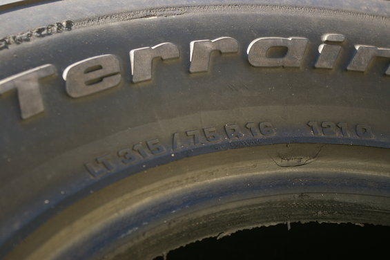 Close-up of a tire with 'terrain' written on it. Tire size LT315/75R16 and date code 1210 are visible