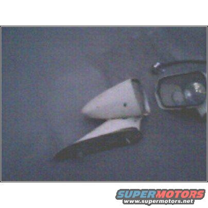 White fender ornament and side mirror against a gray background