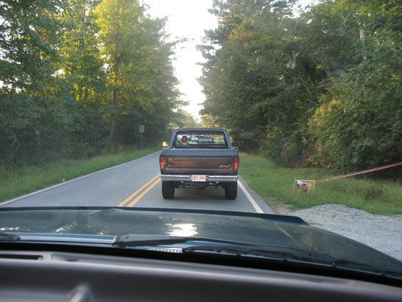 Dark pickup truck with a license plate reading 'VPC 790' driving on a two-lane road
