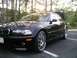 2002 BMW M3 - A black 2002 BMW M3 coupe is parked in a lot with its trunk open, viewed from the front three-quarter angle.