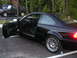 2002 BMW M3 - A black 2002 BMW M3 coupe is parked with the driver's door open, revealing the interior. Another vehicle is visible in the background.
