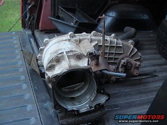 Transfer case with rust and grime, lying in a truck bed